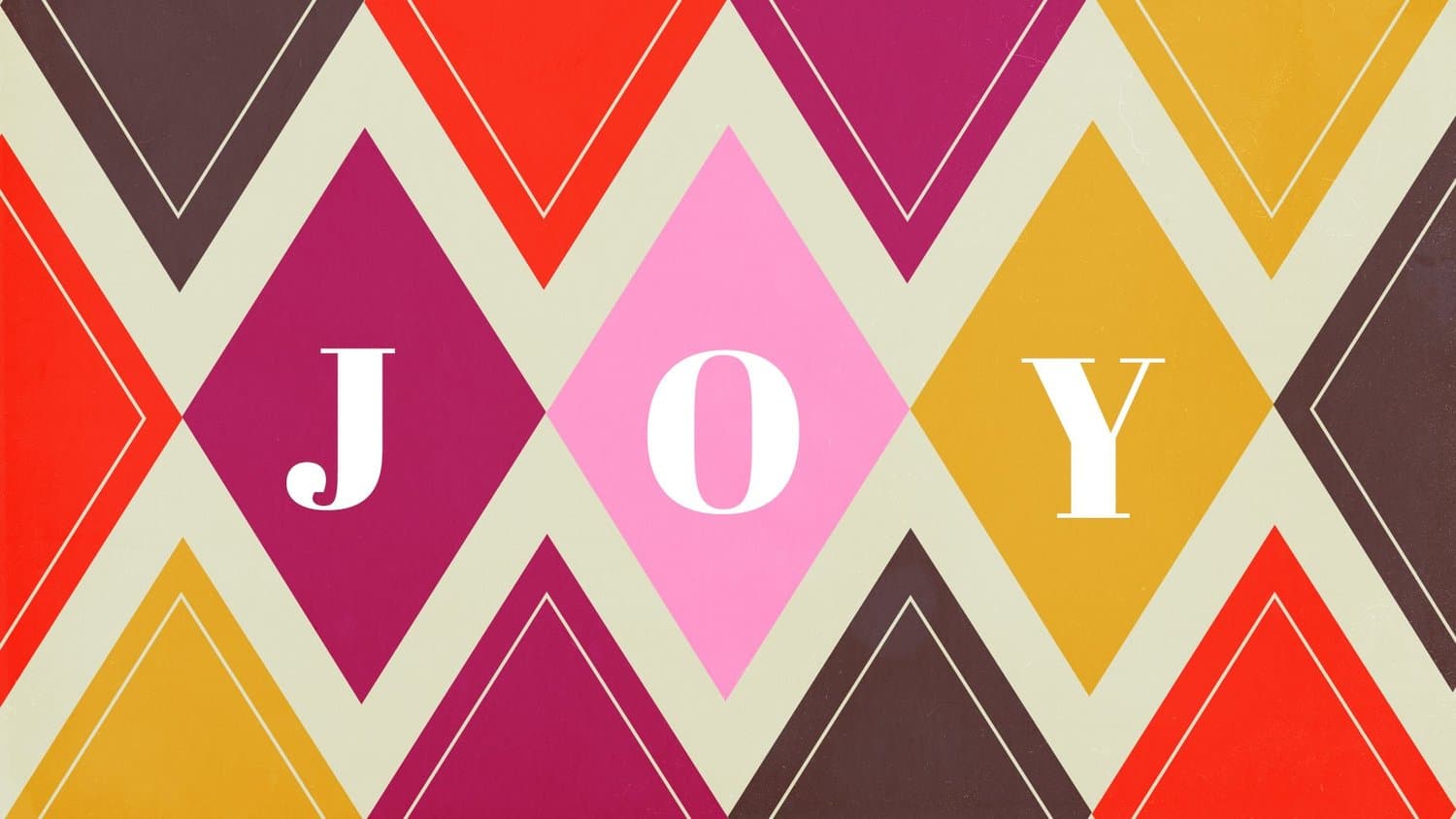 A Christmas slide reading JOY in white serif capitals, each letter set inside a diamond of a repeating harlequin pattern in magenta, pink, gold, red and brown.