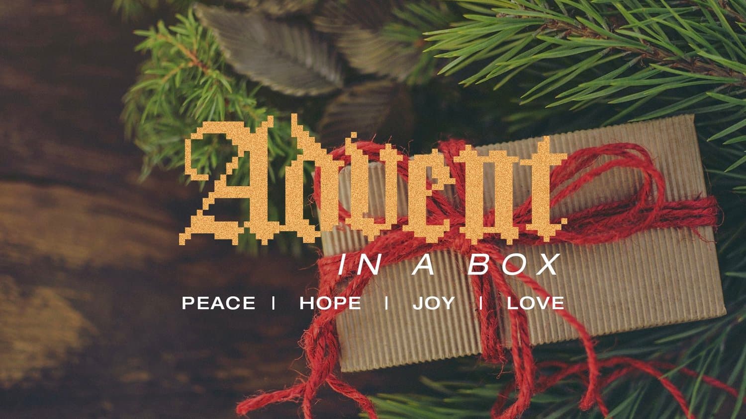 An Advent title slide reading Advent in gold glitter blackletter over a photograph of a kraft paper gift tied with red twine among pine branches, with IN A BOX and PEACE, HOPE, JOY, LOVE.