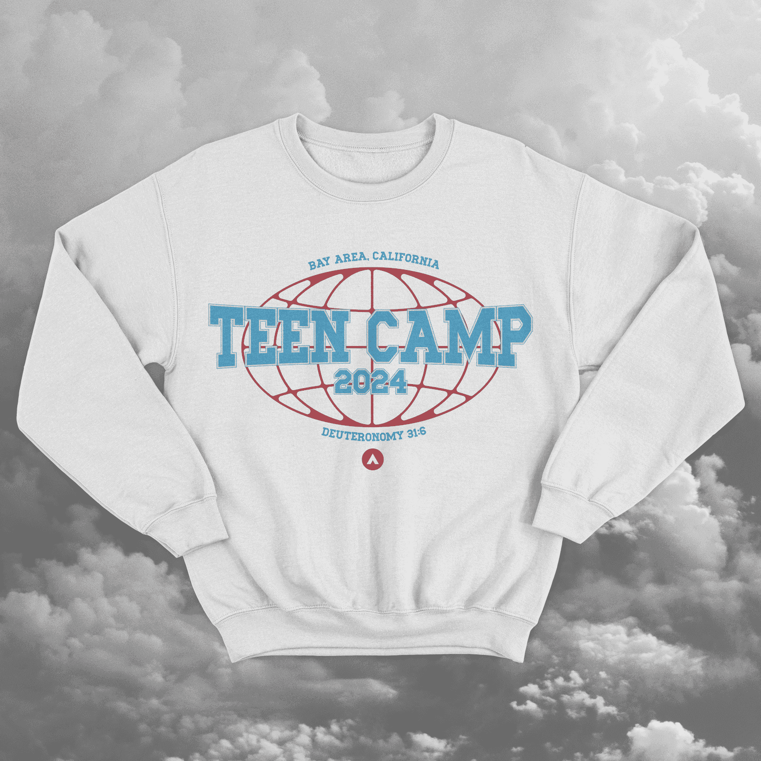 A white crewneck sweatshirt mockup against grey clouds, printed TEEN CAMP 2024 in blue collegiate type across a red globe outline, ringed by BAY AREA, CALIFORNIA and DEUTERONOMY 31:6.